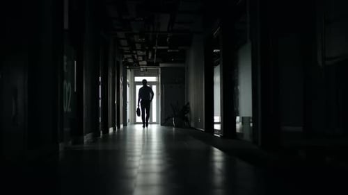 Businessman Walking in Dark Office