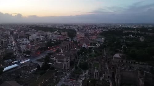 The Eternal City of Rome, aerial over Colosseum and Roman Forum during early morning as sun rises