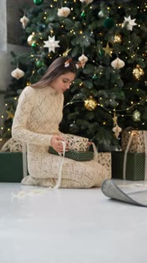 Woman Wrapping Christmas Presents Near Christmas Tree