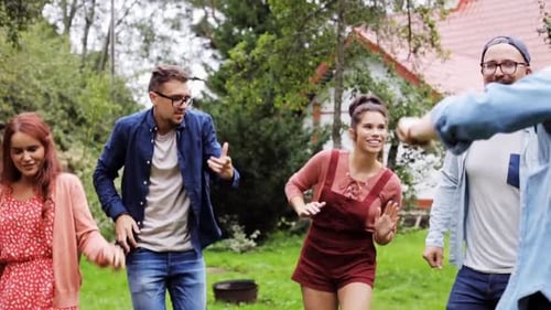 Leisure, Holidays, Fun And People Concept - Happy Friends Dancing At Summer Party In Garden