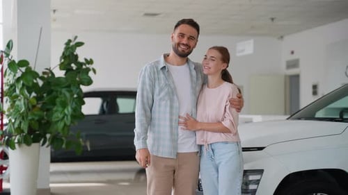 Happy Couple Showing Keys to New Car at Dealership