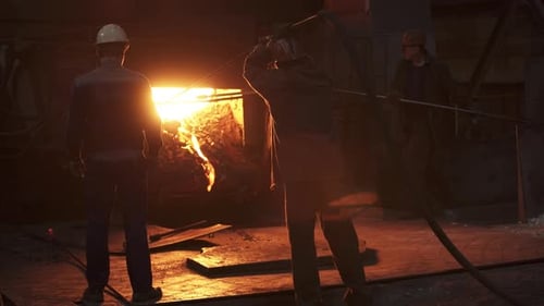 Artisan Workers in a Foundry are Manipulating Molten Metal Using Their Craft and Tools Stock Clip