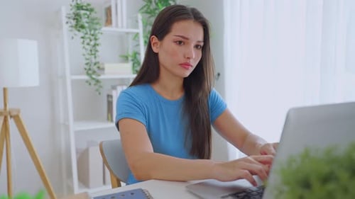 Young Adult Woman Works on Laptop at Home
