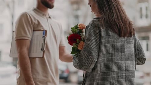 Woman Receives Flowers and Gift from Delivery Person