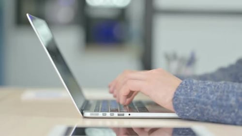 Seitenansicht männlicher Hände, die auf dem Laptop tippen