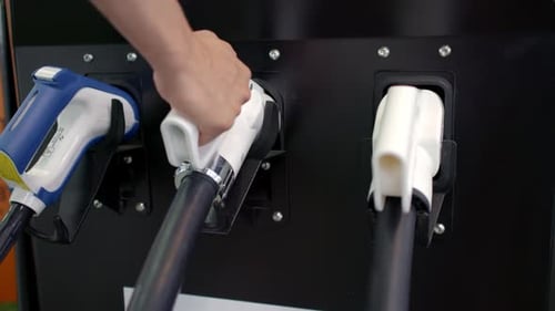 Close Up of a Gas Pump Nozzle in Use for Refueling a Vehicle Showcasing This Essential Action Media