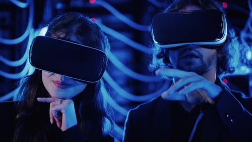 Ein Mann und eine Frau verwenden Virtual-Reality-Headsets in einem Serverraum