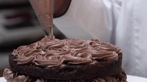 Delicious Chocolate Cake Being Decorated with Frosting