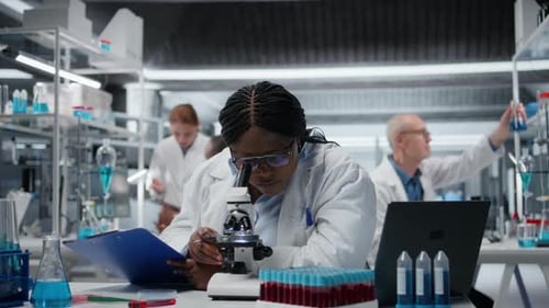 Woman Using Microscope in Modern Science Lab