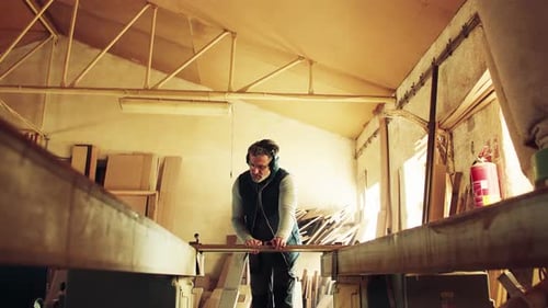 A Man Worker In The Carpentry Workshop, Working With Wood.