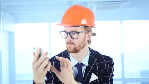 Architectural Engineer Using Smartphone Browsing Online at Work