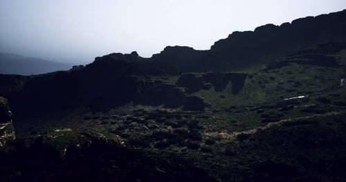 Mountain Landscape Viewed at Dusk with Dramatic Shadows and Rocky Terrain