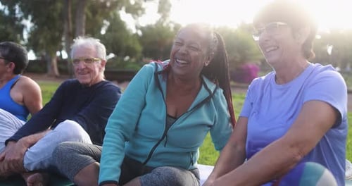 Multiracial senior people having fun after workout exercises outdoor with city park in background