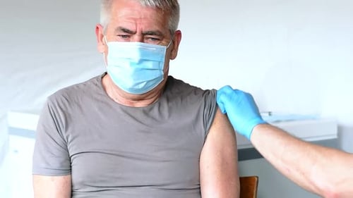 Senior Receives Arm Injection in Hospital Environment