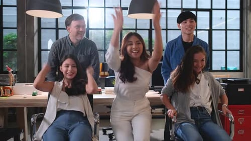 Wide shot of business man and woman enjoy and fun to play with chair rally in office for relaxing