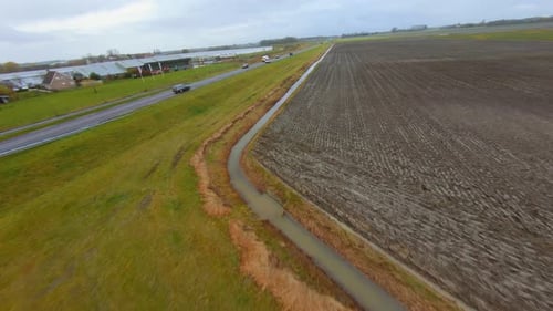 Drone following a car on a busy main road going through a rural area.