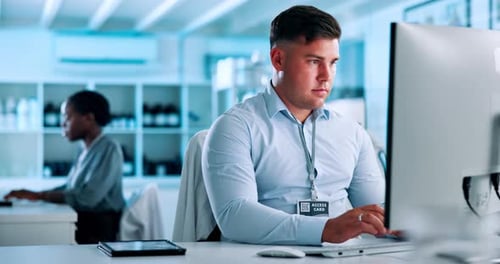 Man Typing at Computer in Modern Office