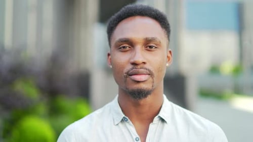 close up portrait serious African American man looking into the camera outside. Face of confident