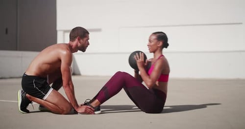 Woman Doing Sit-ups with Medicine Ball With Assistance