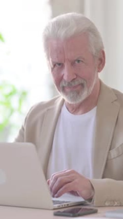 Thumbs Up by Old Man Using Laptop in Office, Vertical Video