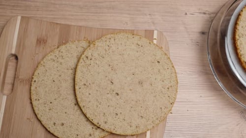 D'en haut, sur une table en bois, les ingrédients d'un gâteau fourré à la compote d'orange et à la crème.