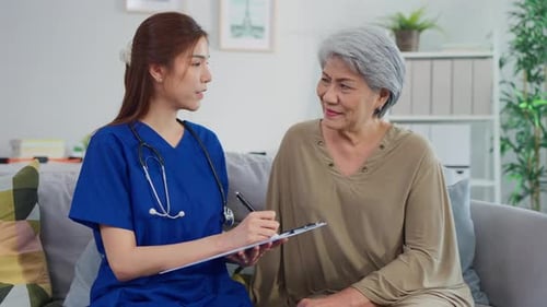 Asian beautiful caregiver examine senior woman patient at nursing home.
