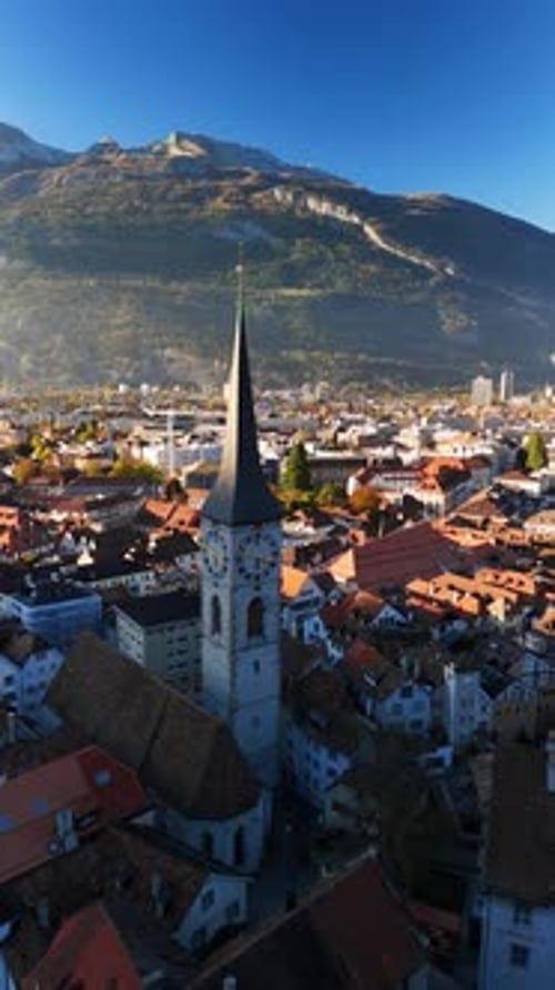 Spire and clock tower of the St. Martin's Church in Chur, Switzerland aerial drone