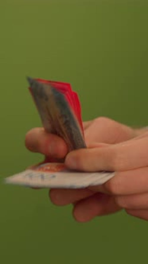 Une main tient une carte sur un fond vert vif affichant divers détails