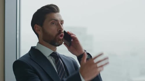 Portrait Furious Manager Calling Phone Gesturing Emotionally at Office Window