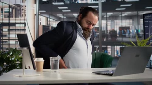 Businessman with Lower Back Pain and Stiffness Stretching at His Office