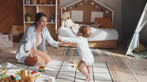 Woman and Baby Playing with Toys on Rug