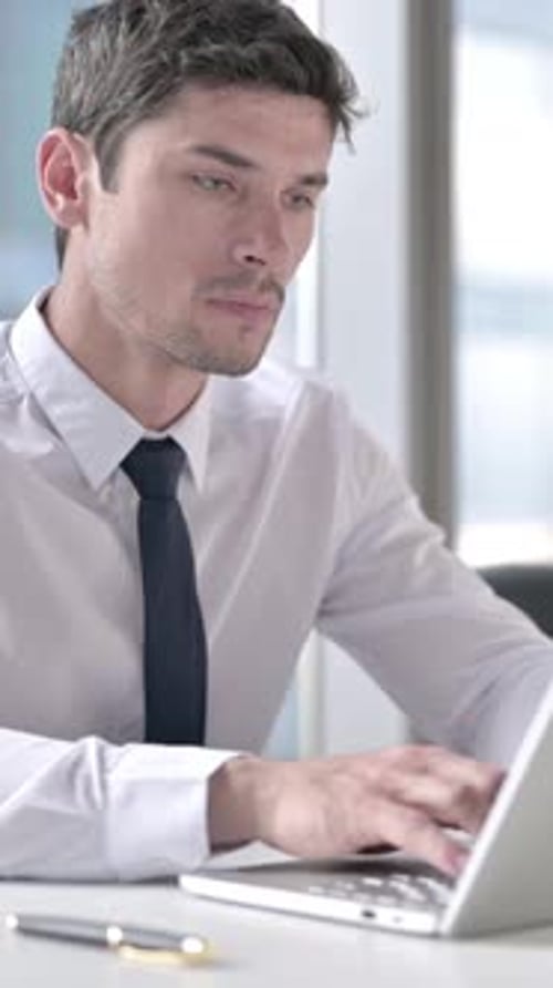 Excited Businessman Works on Laptop in Office