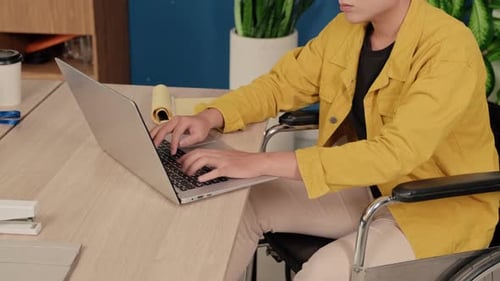 Adult Man in Wheelchair Working on Laptop at Office