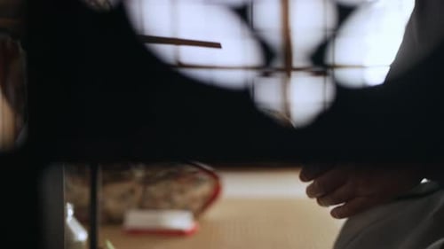 Man Making Tea With A Cup Of Hot, Steaming Water And Pouring It Into A Bowl In A Traditional Japa...