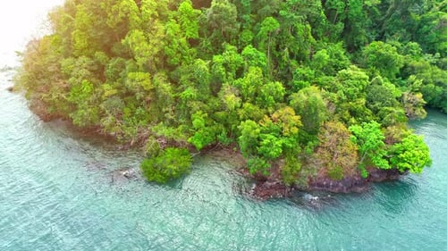 Aerial view reveals lush coastal and mountains on tropical island. 4K.