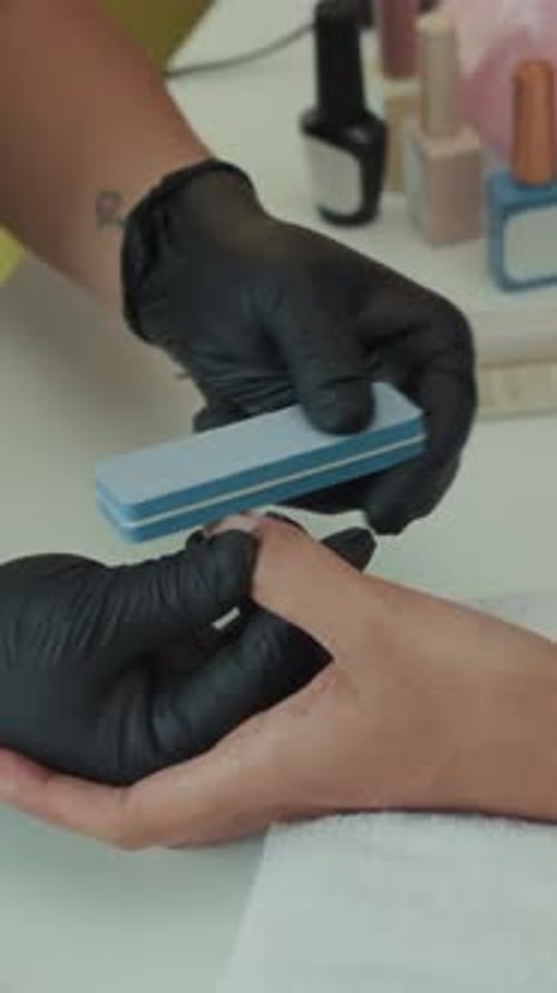 Manicurist Files Client's Nails in Salon