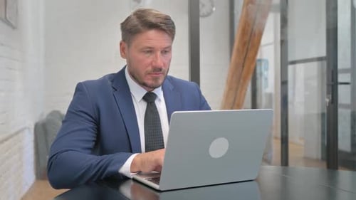 Professional Man Working on Laptop in Modern Office
