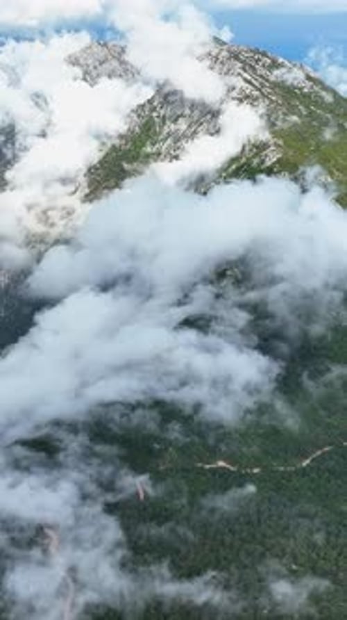 Vertical Video Aerial View of CloudEmbraced Mountain Scenery Serenity Amidst Nature's Splendor