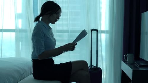 Attractive young businesswoman analyzes financial data in her hotel room