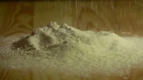 Flour Falling on Pile on Wood Surface
