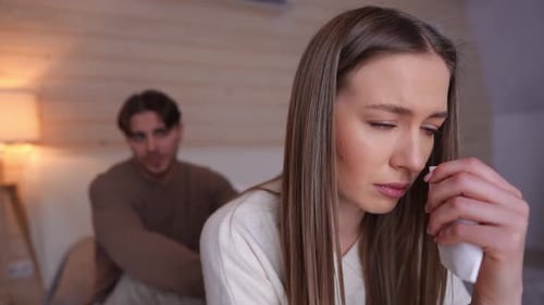 Distressed Woman Cries While Man Gestures in Background
