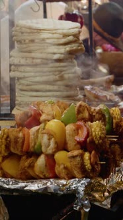 Vertical video Delicious grilled meats and sausages displayed in a holiday market setting