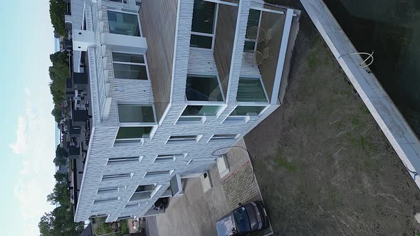 Vertical format: Aerial view of stylish waterfront building with prow ...