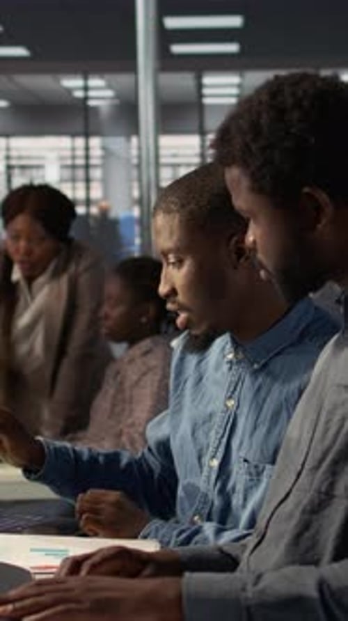 Vertical Video African American Team Examines Monthly Revenue Balance on a Computer