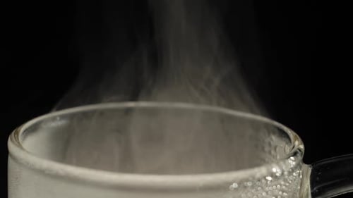 Kochendes Wasser Dampf kondensiert an der Seite der Teekanne
und steigt auf