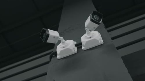 Two Security Cameras Mounted on Concrete Pillar