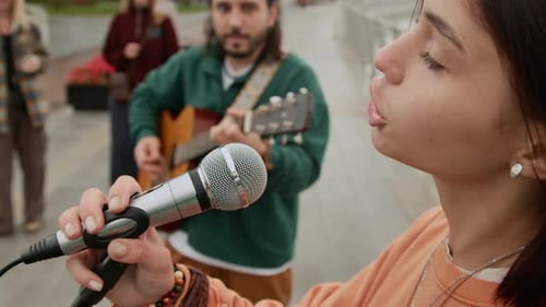 Face of Teenage Female Busker Singing Emotional Hit Song in Street