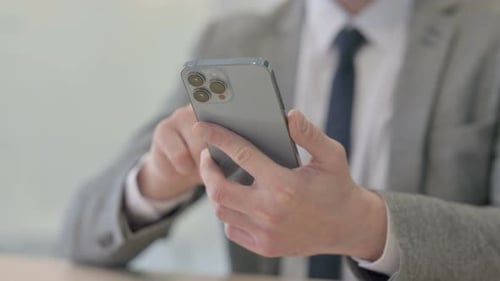 Close up of Young Businessman Browsing Internet on Smartphone