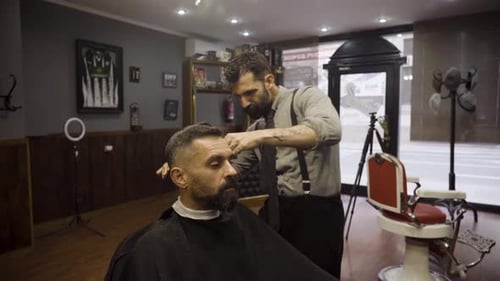 Professional Barber Cuts Hair Of His Client With Scissors - close up