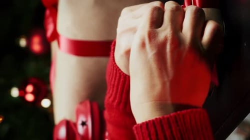 Hands Tying Red Ribbon on Christmas Gift